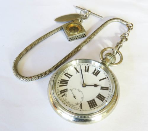 fig 1. An open face 1930s silver pocket watch with Roman numerals and a subsidiary seconds dial, attached to a flexible snake chain Albert with a square compass fob.