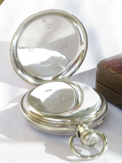 fig 2. An antique open-face sterling silver pocket watch featuring a white enamel dial with black Arabic numerals and a subsidiary seconds dial.
