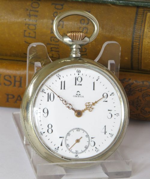 fig 1. An open-face antique Omega pocket watch with a white enamel dial, black Arabic numerals, ornate hands, and a silver-toned metal case.