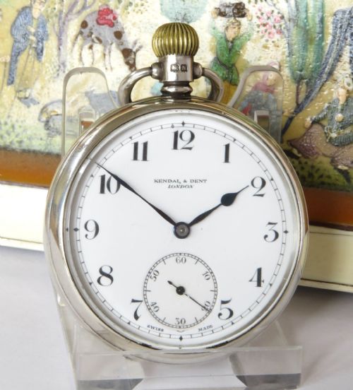 fig 1. A 1930s open-face pocket watch featuring a silver case, white enamel dial with black Arabic numerals, and a subsidiary seconds dial at six oclock.
