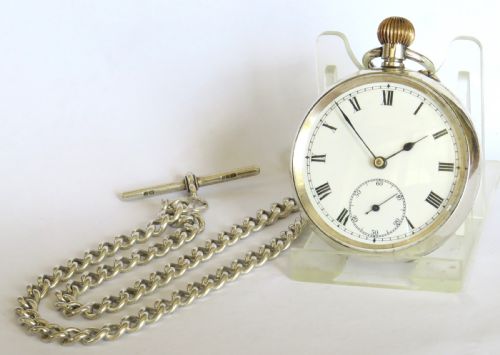 fig 1. An antique Edwardian open-face silver pocket watch with a white enamel Roman numeral dial and an attached silver T-bar chain.
