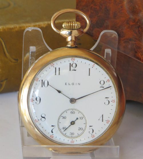fig 1. An Edwardian open-face gold-filled Elgin pocket watch featuring a white enamel dial with black Arabic numerals and a subsidiary seconds dial.