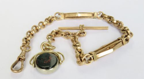 fig 1. An antique rolled gold pocket watch chain with a T-bar, swivel clasp, openwork links, and a spinning seal fob set with a red stone.