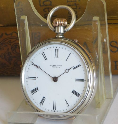 fig 1. An antique Henry Capt silver open-face pocket watch featuring a white enamel dial with black Roman numerals and a rose gold winding crown.