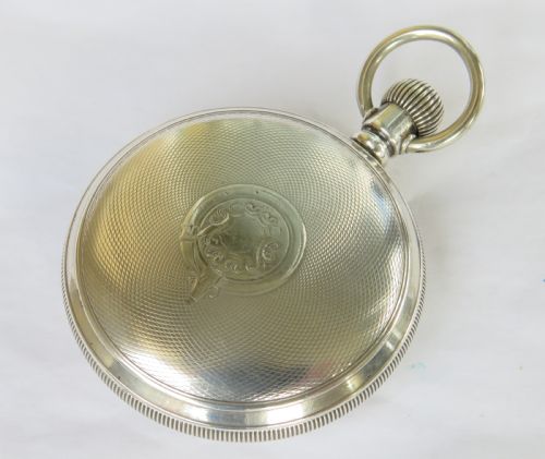 fig 3. An antique open-face silver pocket watch with a white dial featuring Roman numerals, spade hands, and a subsidiary seconds dial.