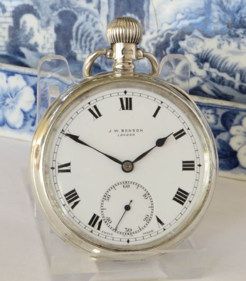 fig 1. An open-face silver pocket watch by J.W. Benson featuring a white enamel dial with black Roman numerals and a subsidiary seconds dial.