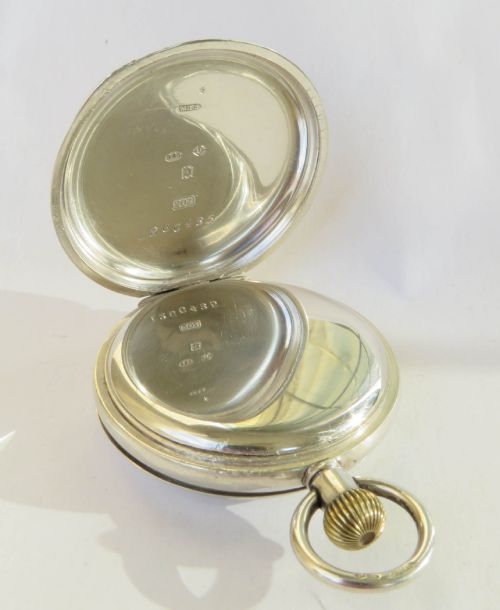 fig 2. An open antique silver full hunter pocket watch displaying a white enamel dial with black Roman numerals and a subsidiary seconds dial.