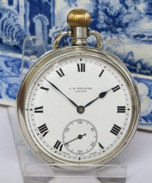 fig 1. An antique open-face silver pocket watch featuring a white enamel dial with black Roman numerals and a subsidiary seconds dial.