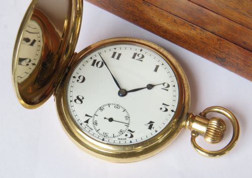 fig 1. An open vintage gold-plated full hunter pocket watch displaying a white enamel dial with black Arabic numerals and a subsidiary seconds dial.