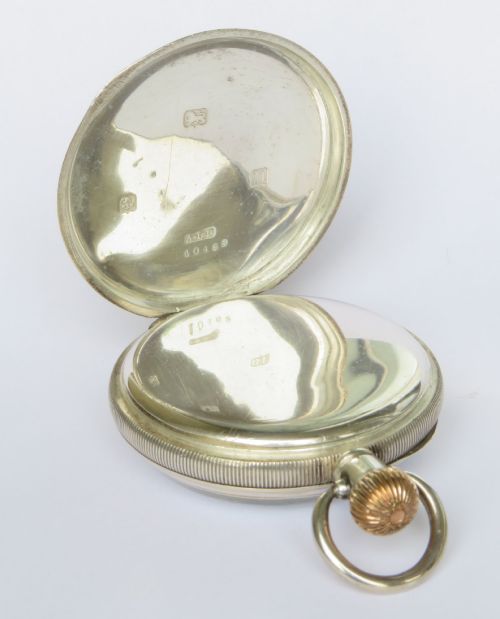 fig 2. An open-face antique silver pocket watch featuring a white enamel dial with black Arabic numerals, a sub-seconds dial, and a ribbed gold-toned crown.