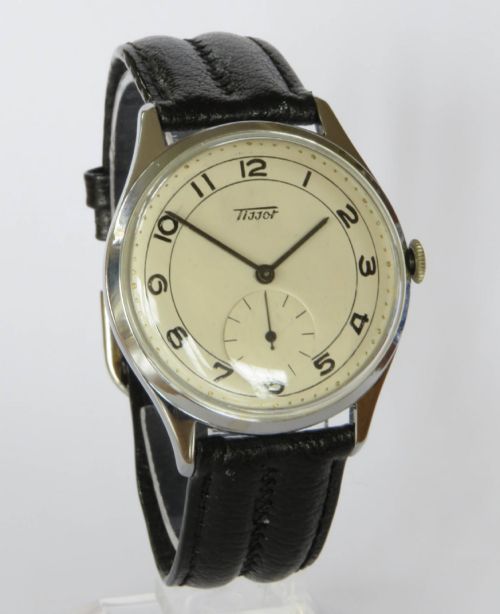 fig 1. A 1950s Tissot gents wristwatch featuring a cream dial with black Arabic numerals, a sub-seconds subdial at six oclock, a steel case, and a black leather strap.