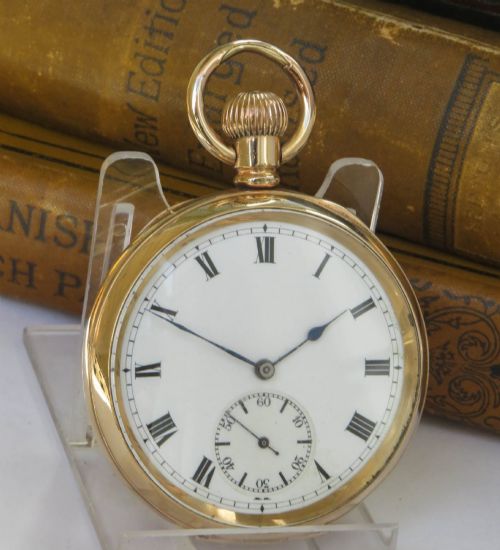 fig 1. A gold open-face pocket watch featuring a white enamel dial, black Roman numerals, a sub-seconds dial, and blued steel hands.