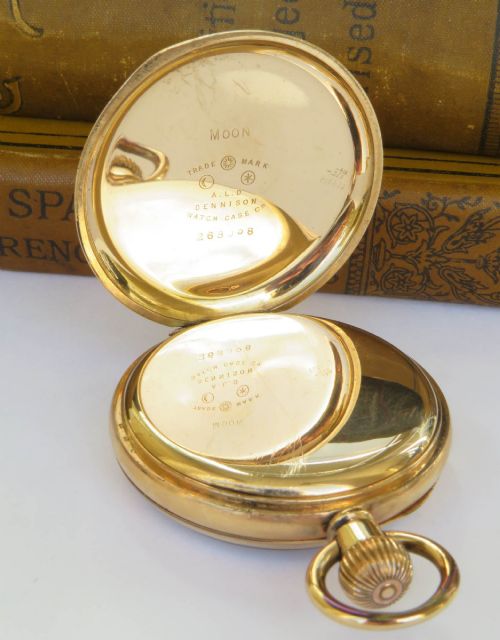 fig 2. A gold open-face pocket watch featuring a white enamel dial, black Roman numerals, a sub-seconds dial, and blued steel hands.