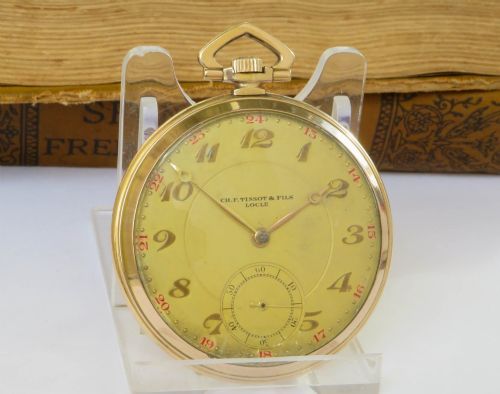 fig 1. An open-face Art Deco pocket watch featuring a gold case, champagne dial with stylized Arabic numerals, sub-seconds dial, and geometric top bow.
