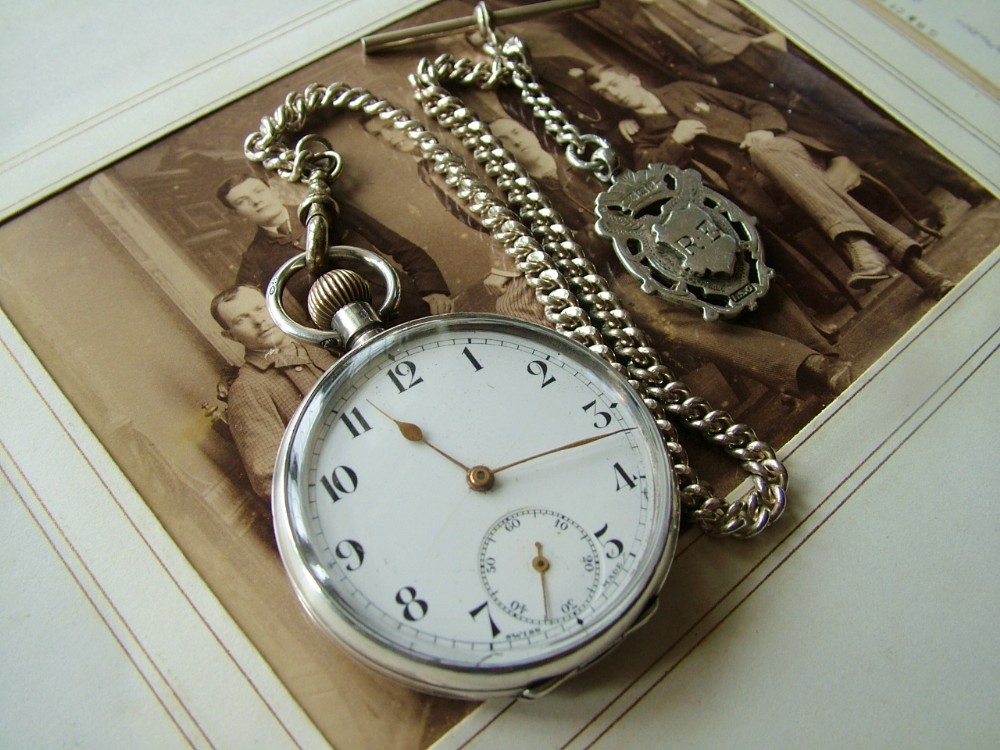 An antique pocket watch and chain, circa 1910s