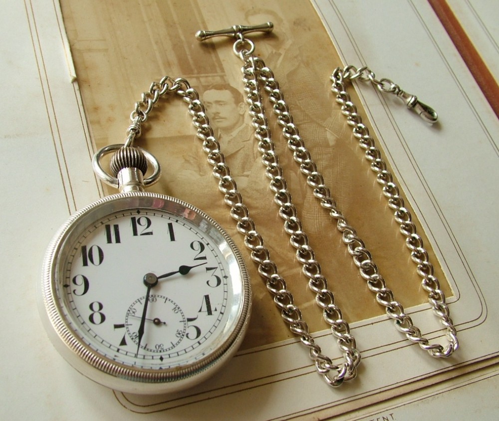 An antique pocket watch and chain, circa 1910s