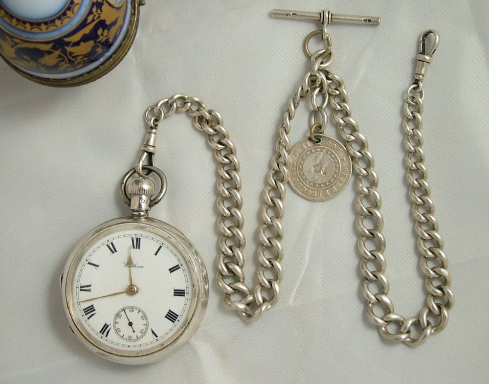 An antique silver Waltham pocket watch and chain