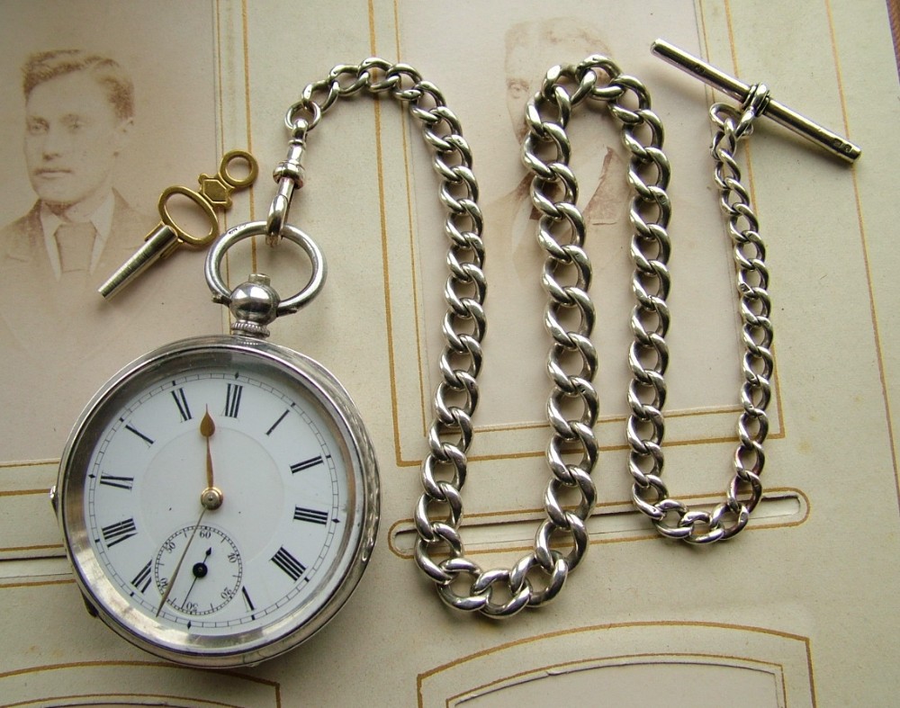 An antique silver pocket watch and chain