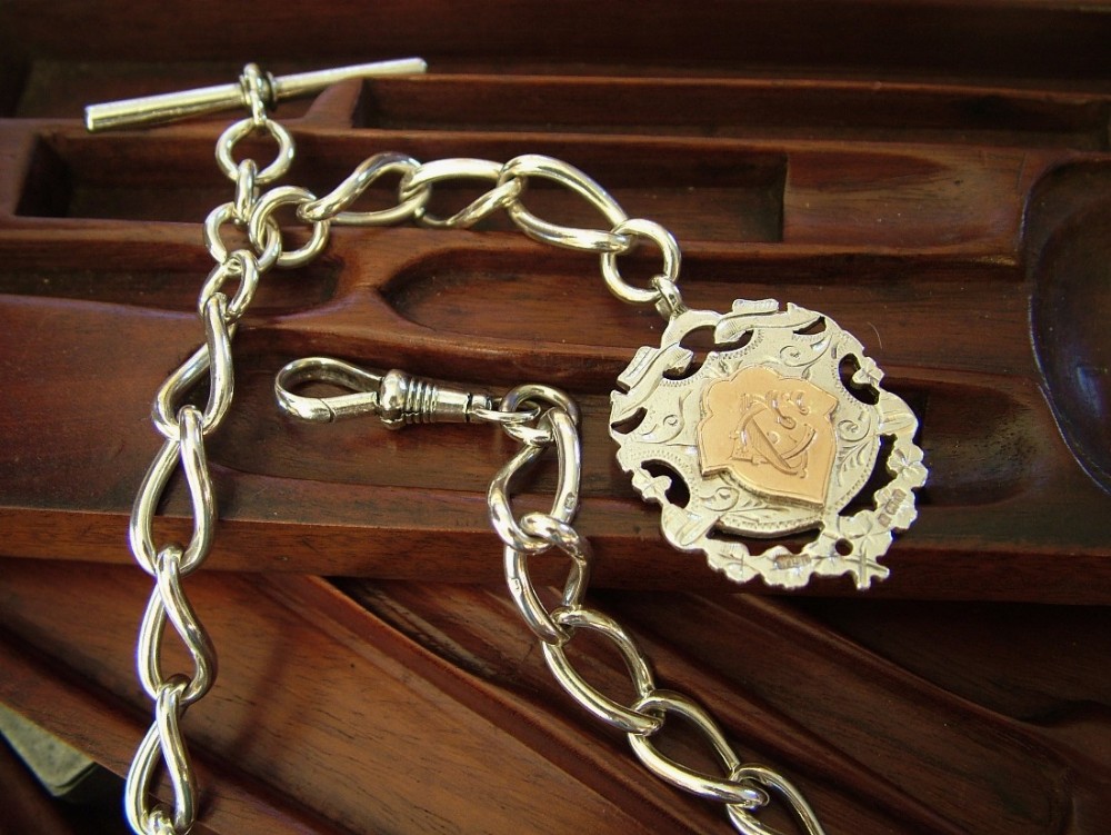 An antique silver watch chain and fob
