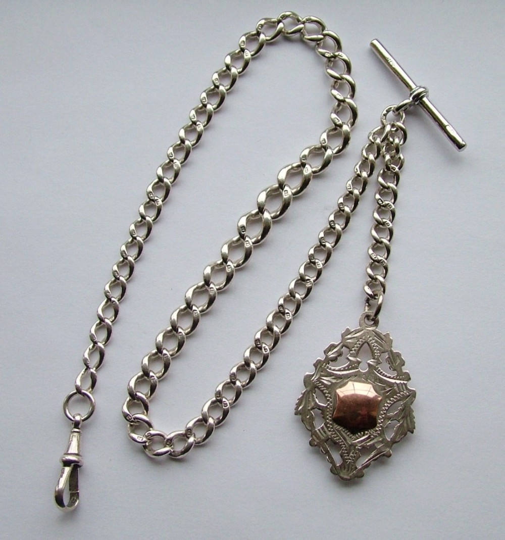 An antique silver pocket watch chain and fob