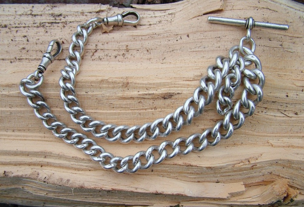 A chunky antique silver double watch chain