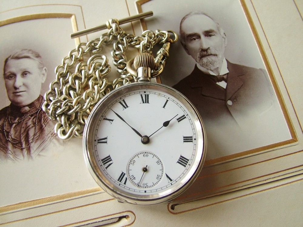 An antique silver pocket watch with chain