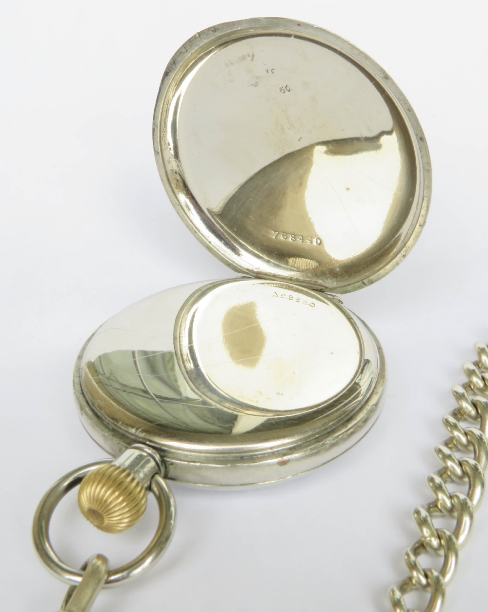 An open-face 1930s Doxa pocket watch with a white enamel dial, black Roman numerals, sub-seconds dial, and attached silver-toned Albert chain. View IV