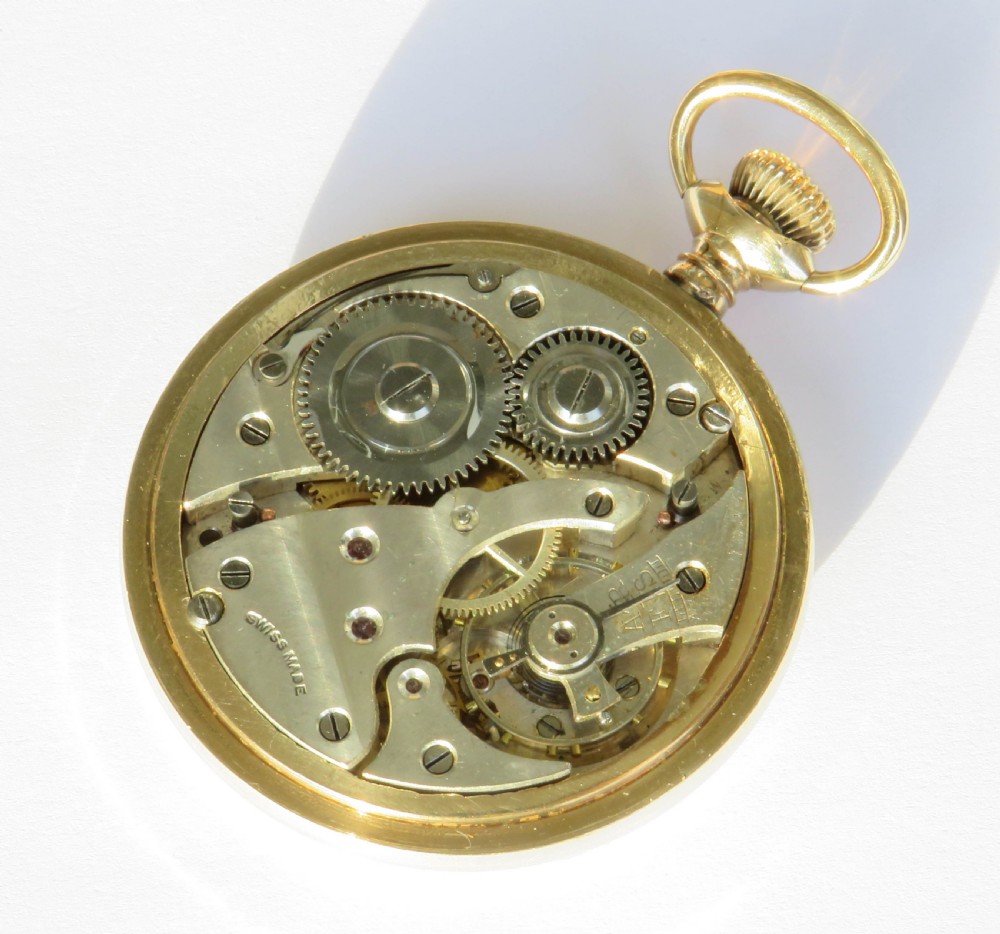 An open-face gold-tone pocket watch featuring a white enamel dial with black Arabic numerals, sub-seconds dial, and attached T-bar chain. View V