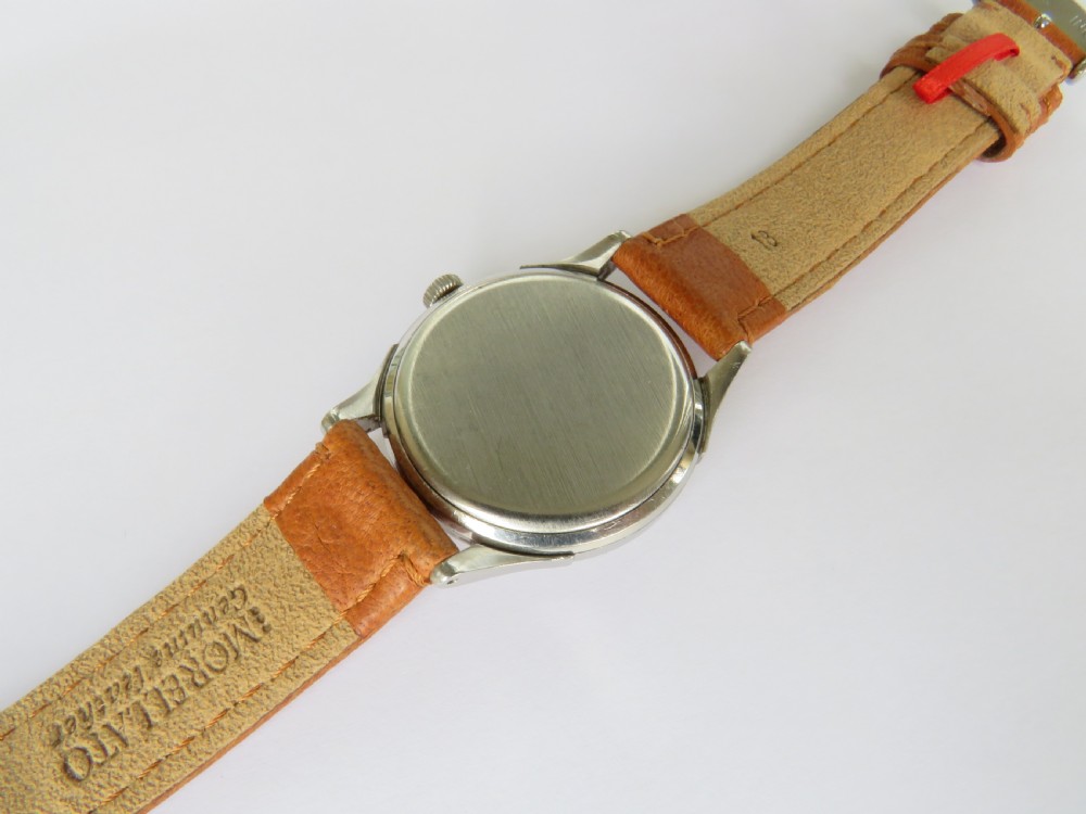 A 1944 gents Omega wristwatch featuring a stainless steel case, off-white dial with Arabic numerals, sub-seconds dial at six oclock, and a tan leather strap. View IV