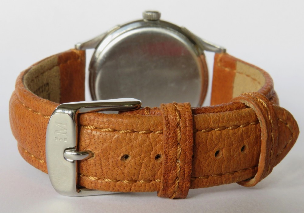 A 1944 gents Omega wristwatch featuring a stainless steel case, off-white dial with Arabic numerals, sub-seconds dial at six oclock, and a tan leather strap. View V