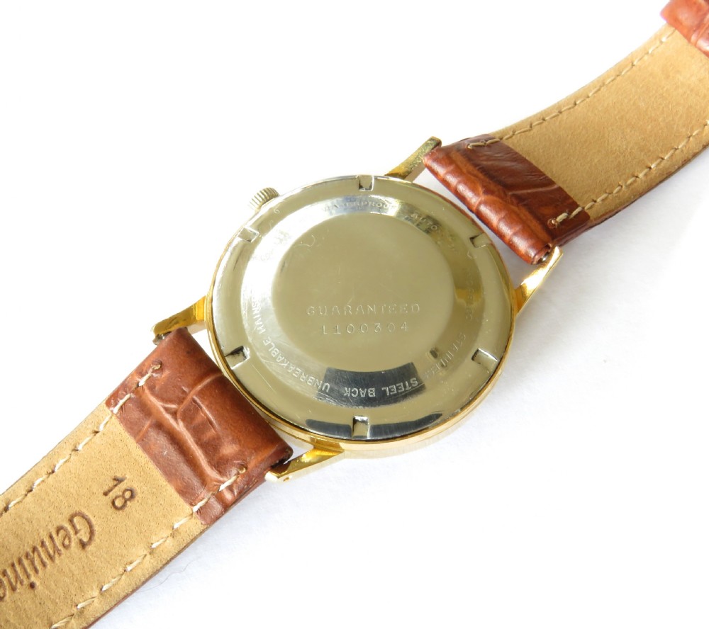 A 1960s Atlantic Super Automatic gents wristwatch with a black dial, gold hour markers, and a brown leather strap. View IV
