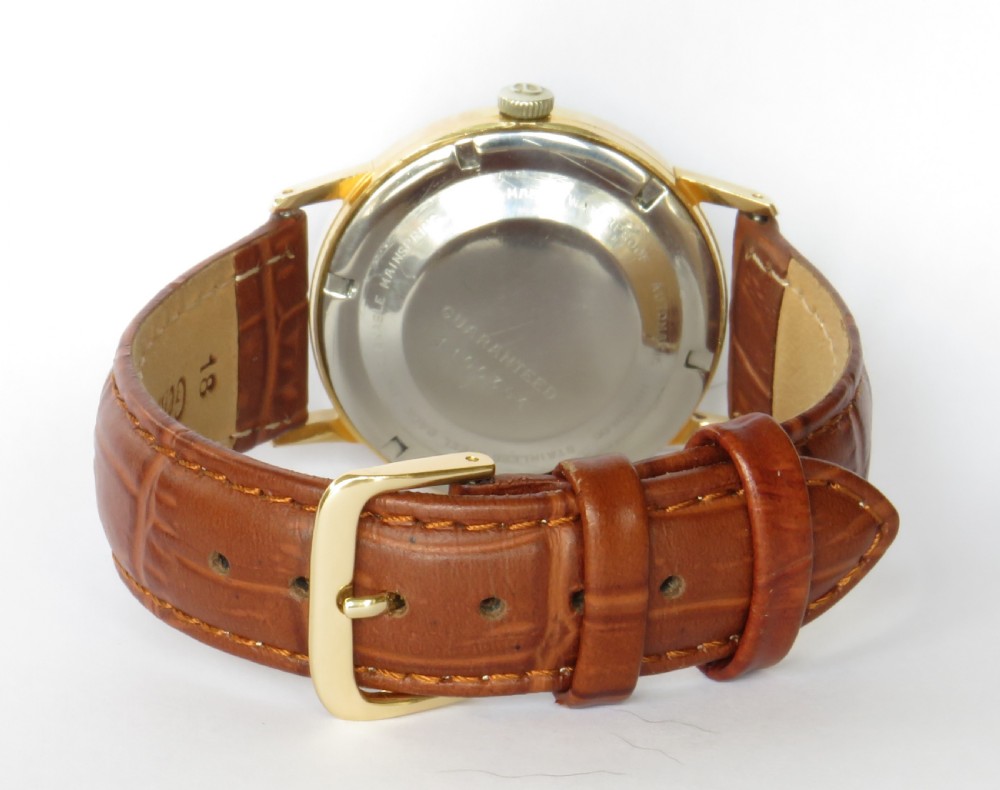 A 1960s Atlantic Super Automatic gents wristwatch with a black dial, gold hour markers, and a brown leather strap. View V