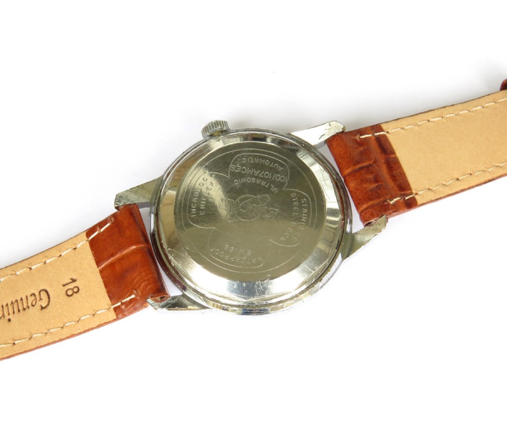 A 1950s mens Enicar Ultrasonic automatic wristwatch featuring a circular silver-tone case, cream dial with hour batons, date window, and a brown leather strap. View III