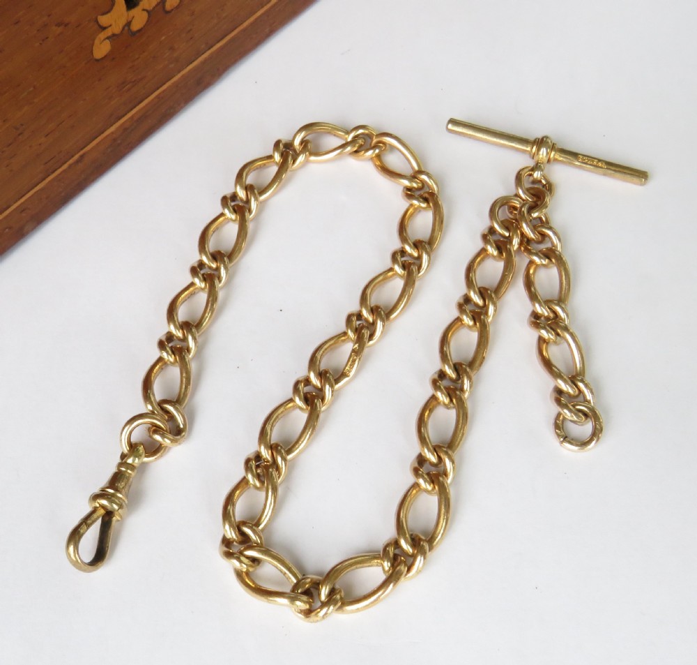 A gold-filled pocket watch chain featuring curb links, a T-bar attachment, and a swivel clasp.