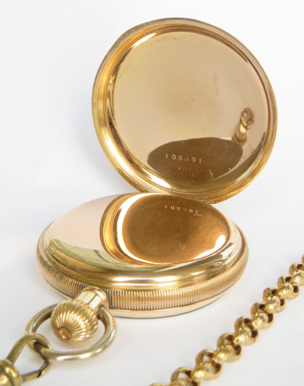 A 1930s gold-toned open-face pocket watch featuring a white enamel dial with Arabic numerals, a sub-seconds register, and a connected Albert chain with T-bar. View III