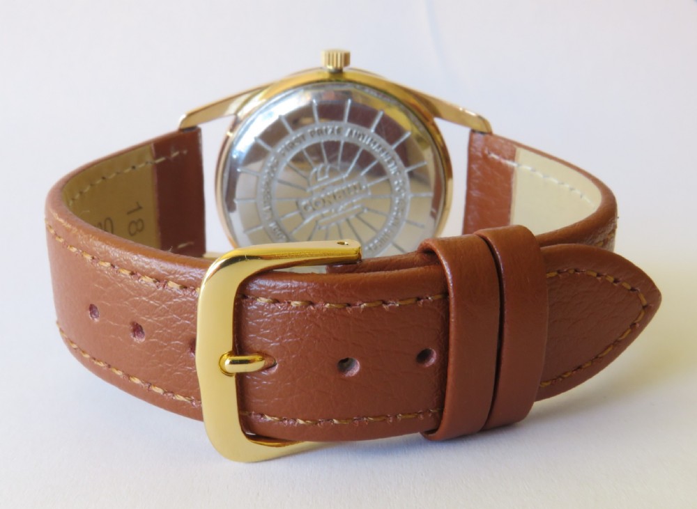 A 1960s gents Consul Dermaphile automatic wristwatch with a gold-tone case, champagne dial, faceted border indices, date window, and brown leather strap. View V