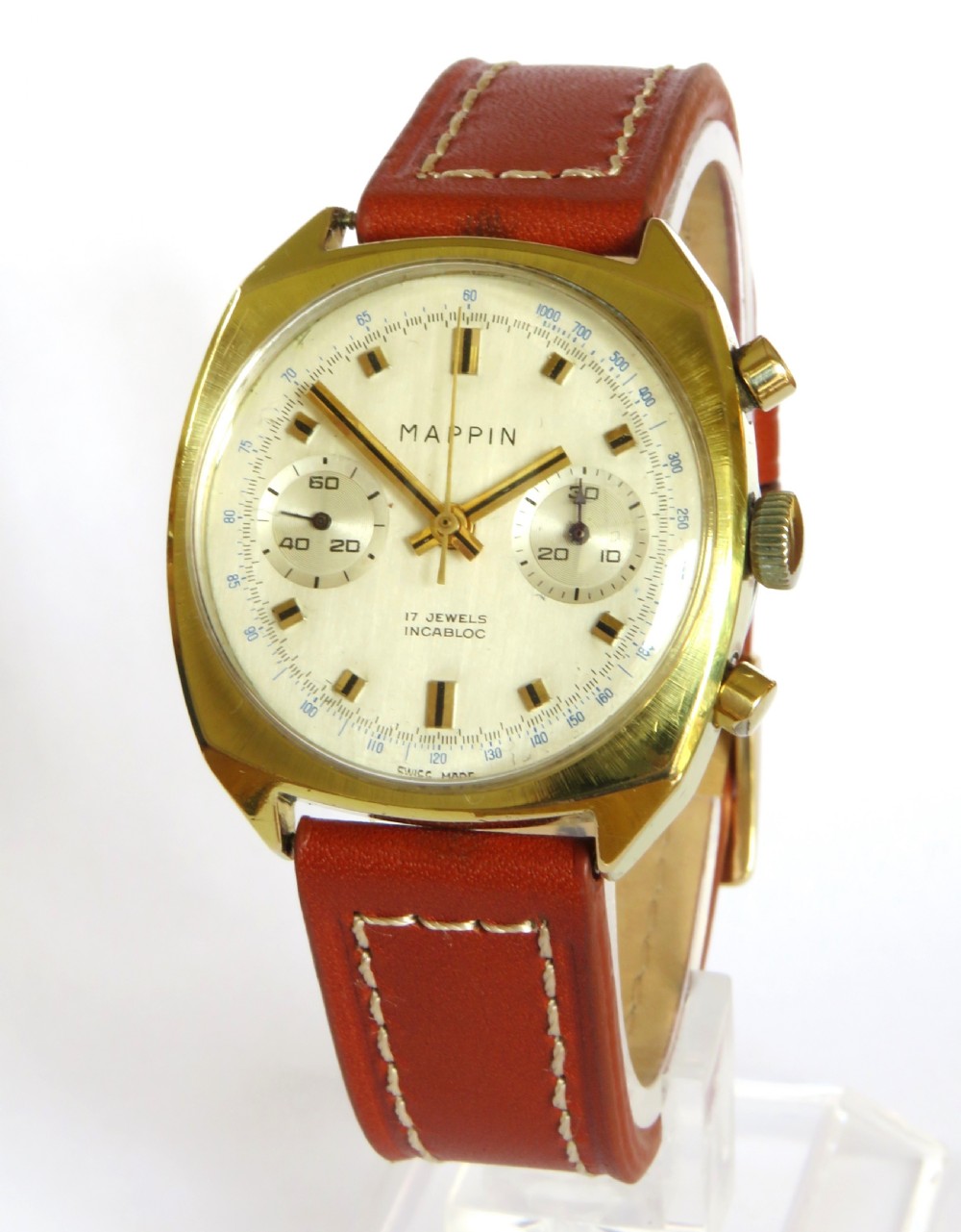 A 1960s Mappin chronograph wristwatch featuring a gold-coloured cushion case, silver-white dial with twin sub-dials, and a brown leather strap.