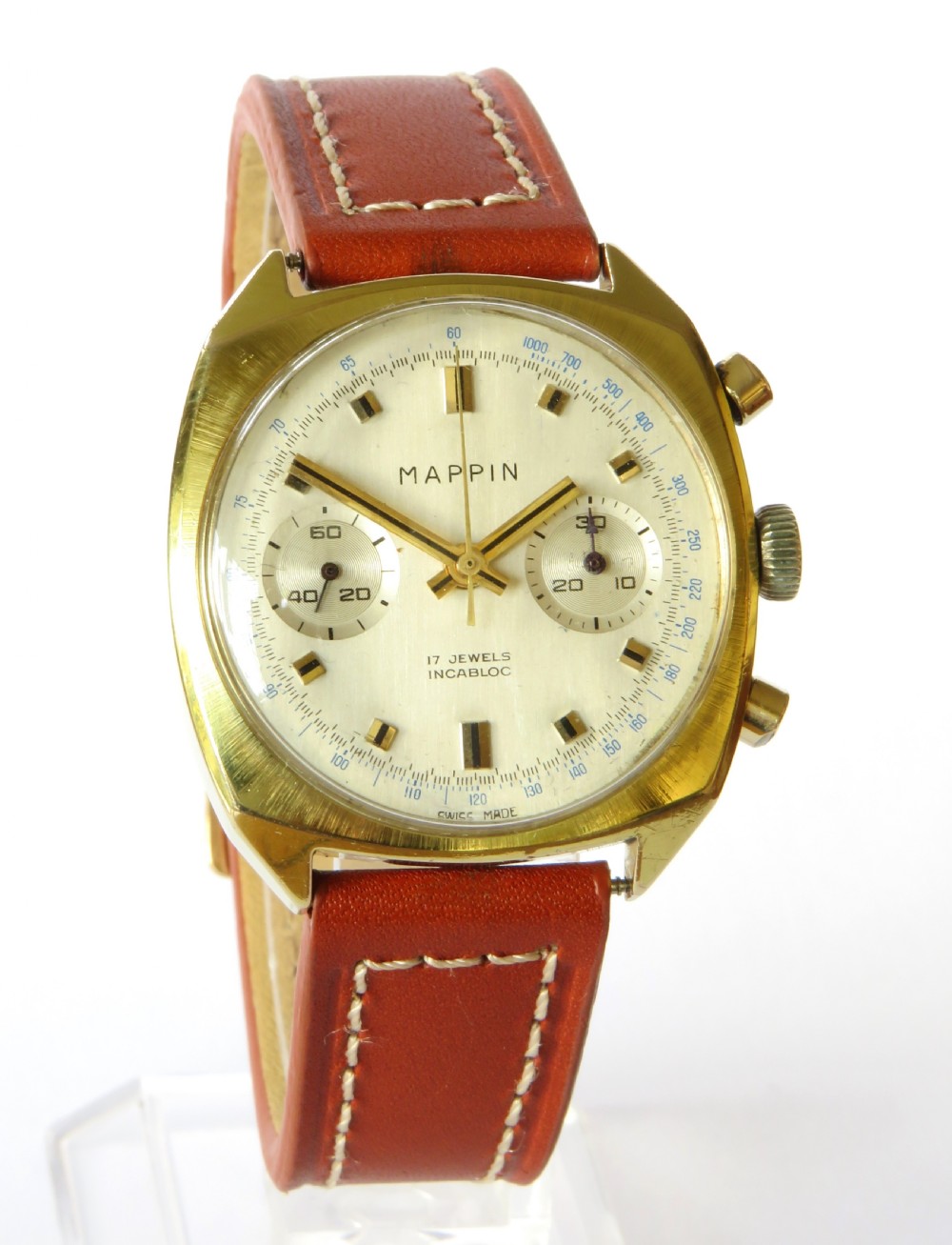 A 1960s Mappin chronograph wristwatch featuring a gold-coloured cushion case, silver-white dial with twin sub-dials, and a brown leather strap. View II
