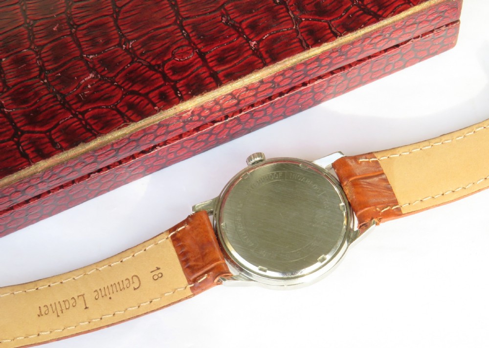 A 1960s Garrard gents wristwatch featuring a champagne gold dial with Arabic numerals and a cognac brown leather strap. View IV