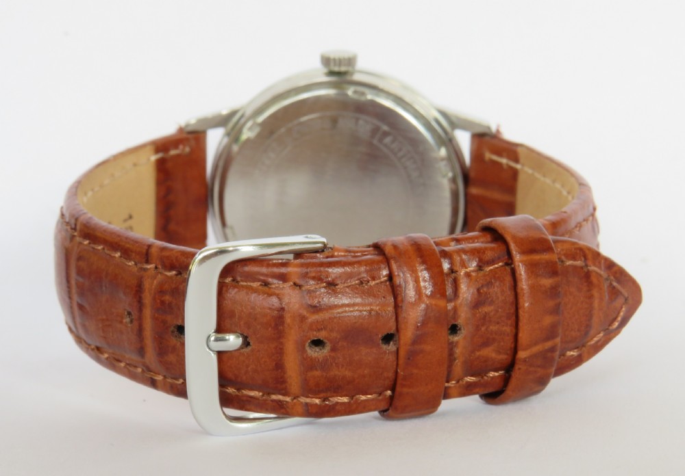 A 1960s Garrard gents wristwatch featuring a champagne gold dial with Arabic numerals and a cognac brown leather strap. View V