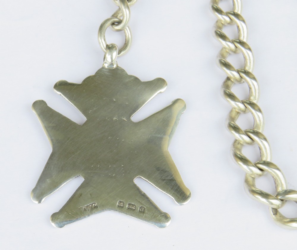 A silver curb link Albert pocket watch chain featuring a T-bar fastener, swivel clasp, and a carved star-shaped fob medallion. View III