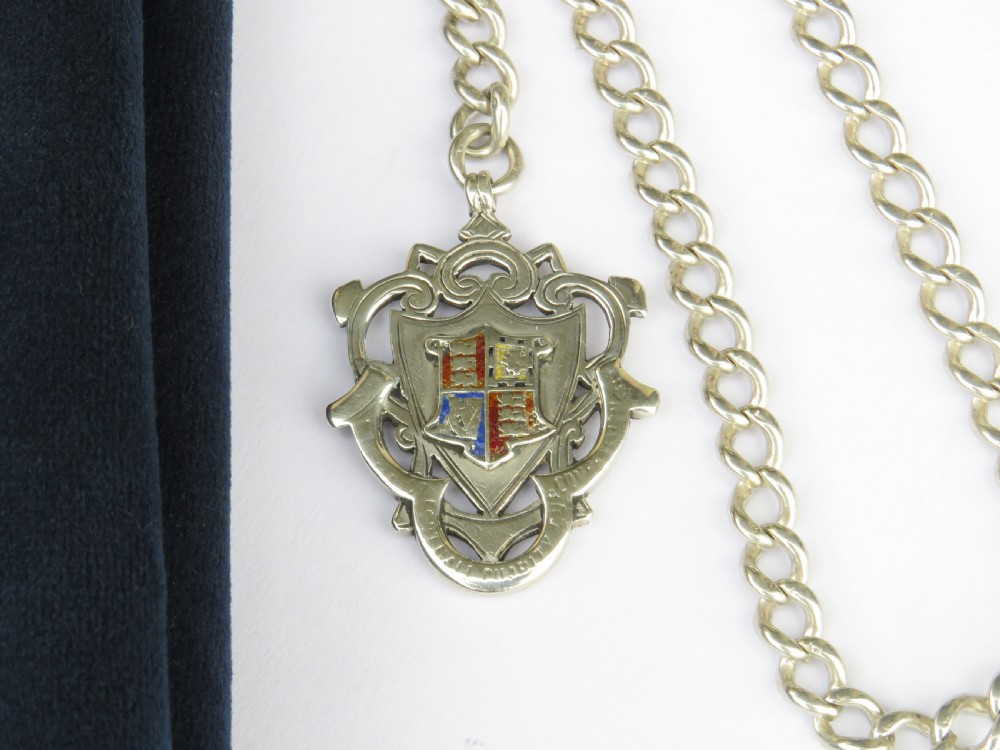 An antique silver curb link pocket watch chain featuring a T-bar, swivel clasp, and a heraldic enamelled shield fob. View II