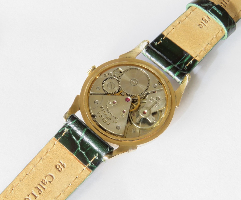 A 1960s gents Felca wristwatch featuring a gold-plated circular case, cream dial with Arabic numerals, and a dark green textured leather strap. View III