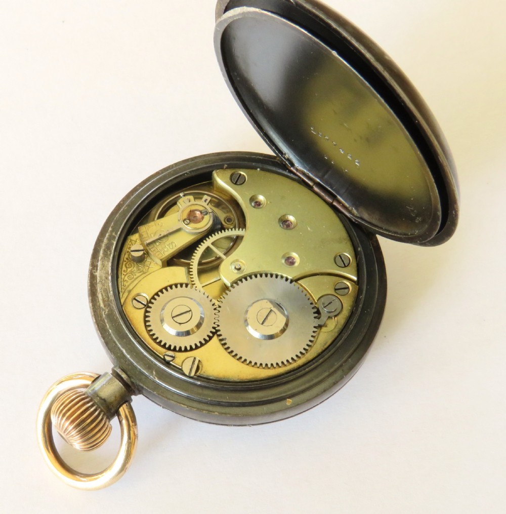 An open-face antique gunmetal pocket watch featuring a white enamel dial with black Roman numerals, gold-toned rim, and a subsidiary seconds sub-dial. View IV