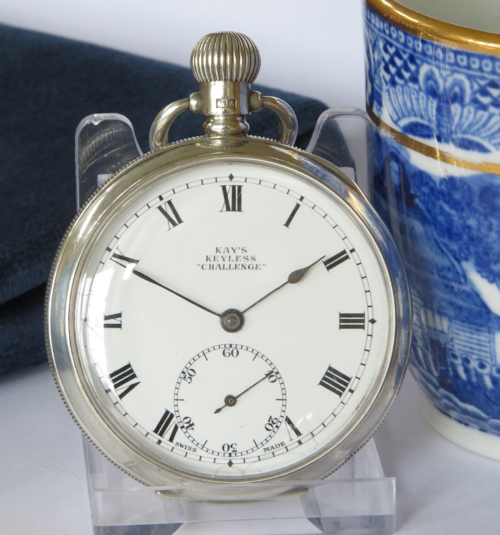An open-face silver pocket watch with a white enamel dial, black Roman numerals, and a sub-seconds dial. View II