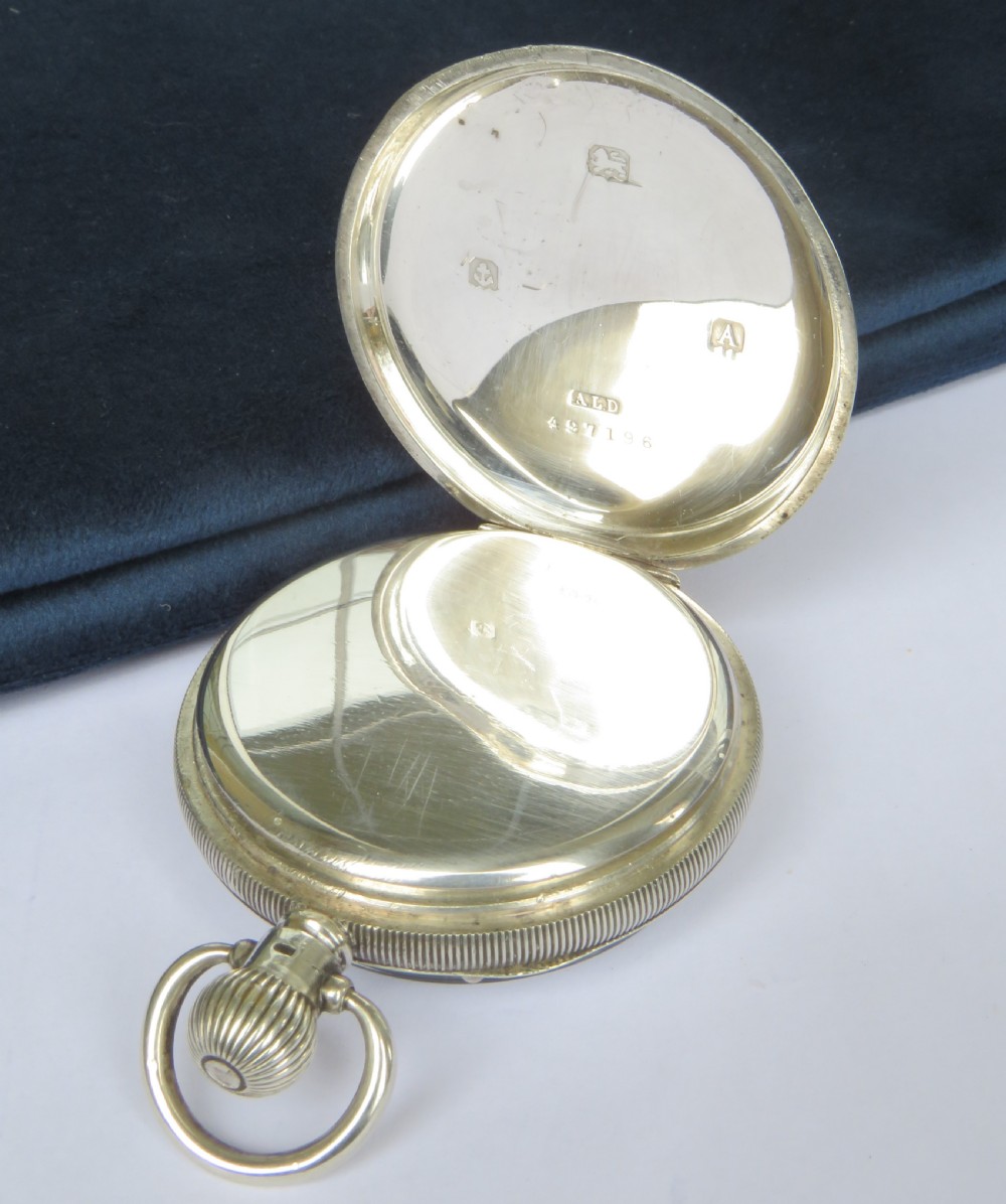 An open-face silver pocket watch with a white enamel dial, black Roman numerals, and a sub-seconds dial. View III