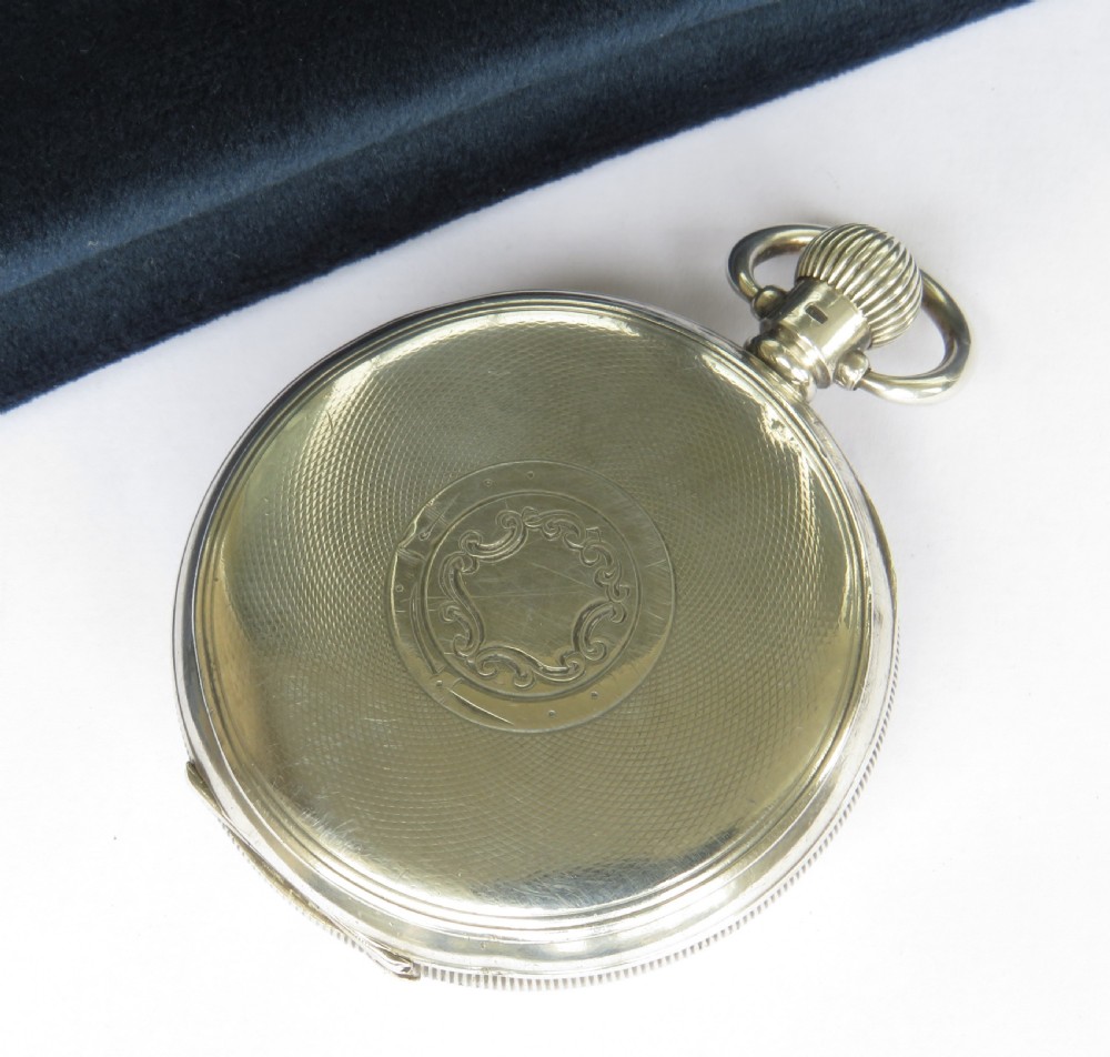 An open-face silver pocket watch with a white enamel dial, black Roman numerals, and a sub-seconds dial. View V