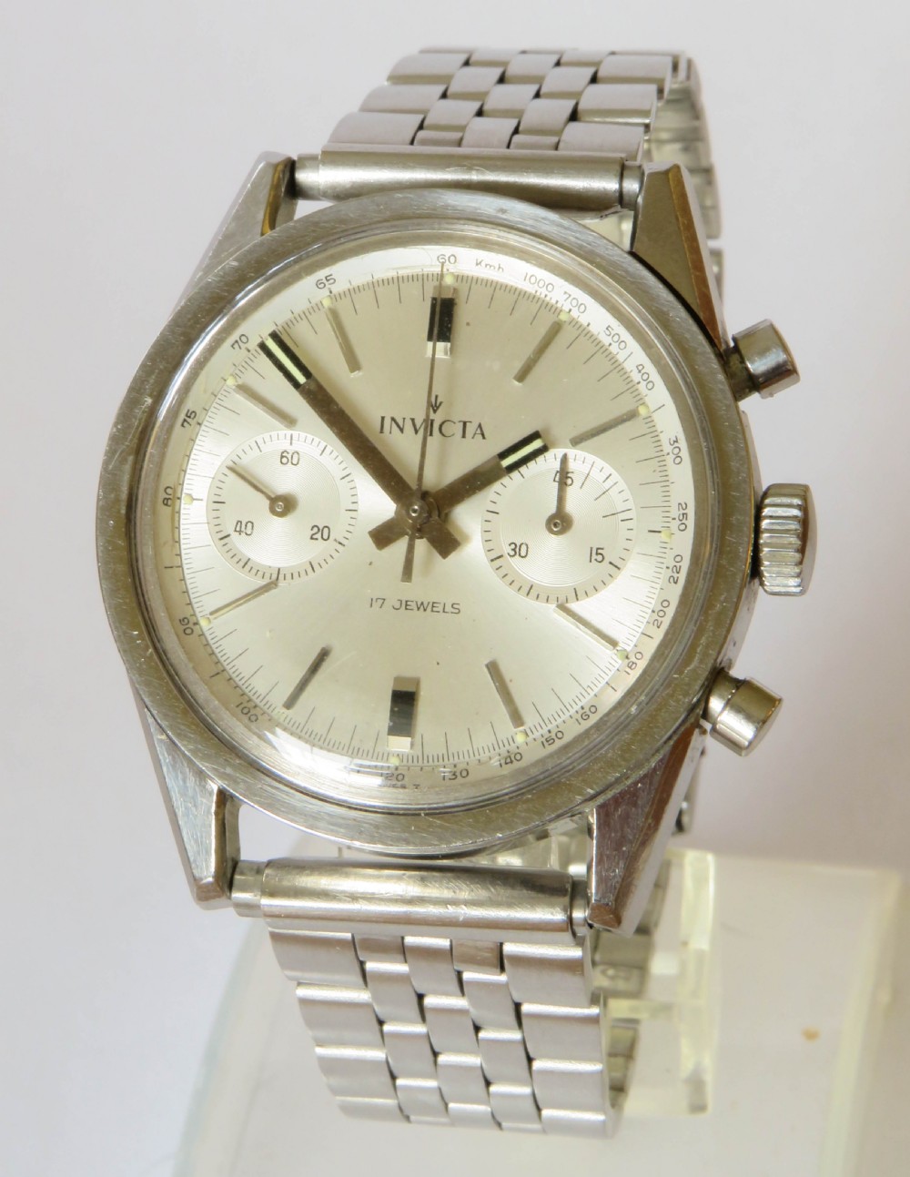 A 1960s Invicta chronograph wristwatch with a silver dial, twin sub-dials, baton indices, and a stainless steel bracelet.