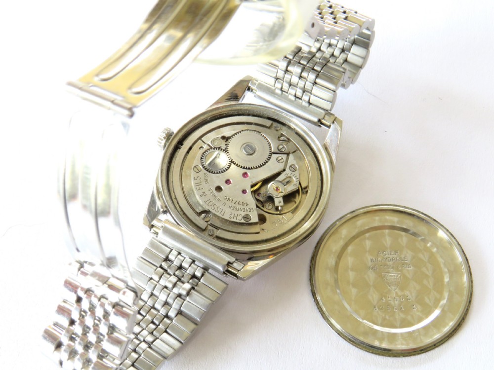 A vintage 1961 Tissot Seastar wrist watch featuring a stainless steel case, patinated cream dial with Arabic numerals, and a multi-link steel bracelet. View III