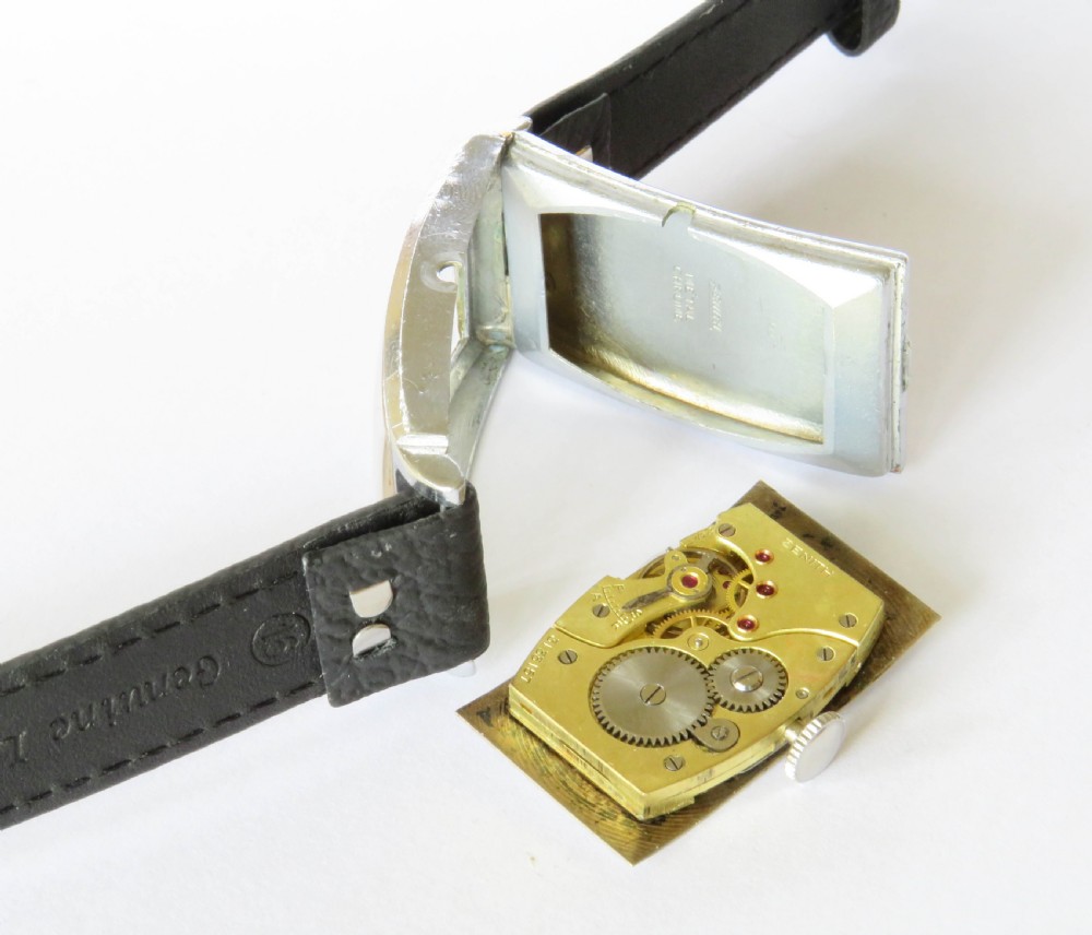 A 1938 gents Zenith wristwatch featuring a rectangular silver-tone case, a cream dial with Art Deco numerals and sub-seconds dial, fitted on a black leather strap. View III